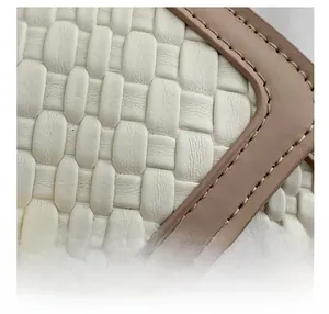 Détail d'un sac à main en cuir tressé blanc avec fermoir doré et coutures nettes