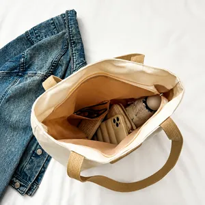 Draufsicht auf das große Fassungsvermögen und das rosa Futter der cremefarbenen Tasche