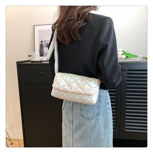 Detailed back view of a white quilted crossbody bag with iridescent finish on a model