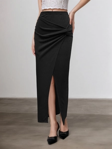 Détail de la jupe longue noire élégante avec nœud à la taille et fente latérale chic