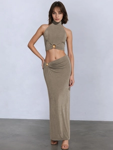 Close-up of golden shell metal buckle on taupe crop top and matching long skirt