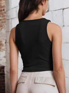 Détail du tissu côtelé noir et du dos nageur sur ce crop top ajusté pour femmes