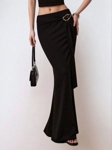 Detail van elegante zwarte maxi-rok met gouden gesp en soepel vallende gedrapeerde stof