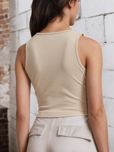 Détail de la texture en maille côtelée et de la coupe dos de ce débardeur court beige