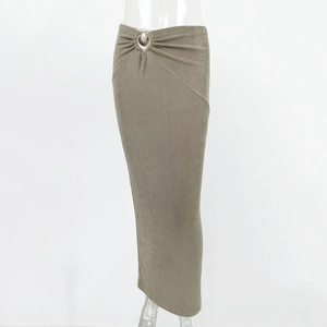 Detail of olive green maxi skirt featuring a metallic shell ornament and pleated waist design