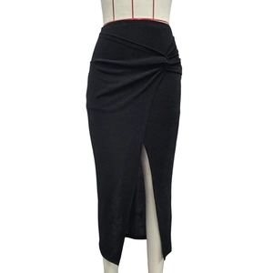 Détail d'une jupe midi noire à taille haute avec nœud à la taille et fente frontale