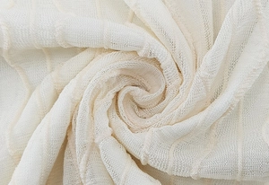 Macro shot of beige jacquard mesh fabric with soft waffle texture and breathable structure