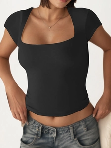 Nauwsluitend zwart T-shirt met vierkante hals gecombineerd met een lichtblauwe jeans