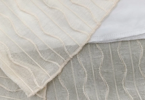 Detailed macro view of beige mesh fabric with wavy embroidery and premium lining detail