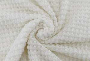 Gros plan d'un tissu gaufré blanc avec des motifs carrés nets et une maille douce et texturée