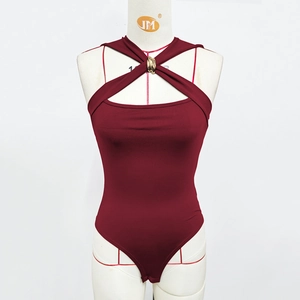 Détail macro du body bordeaux avec décolleté croisé et anneau métallique doré élégant