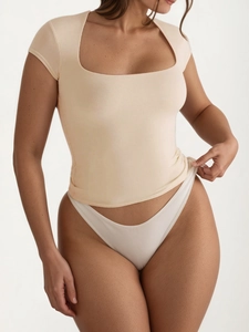 Detail van de vierkante hals top in abrikoos met een aansluitende slim-fit textuur