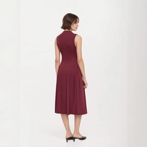 Detail view of burgundy sleeveless knit dress with pleated A-line skirt and chic mock neck