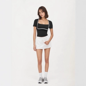 Dettaglio della t-shirt nera slim con scollo a quadrato, profili bianchi e minigonna