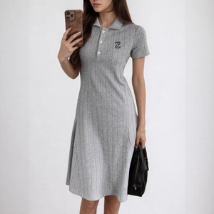 Détail de la texture de la robe polo en tricot gris avec boutons et logo brodé