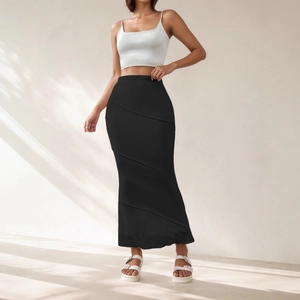 Détail d'une jupe longue noire taille haute avec empiècements et ourlet sirène