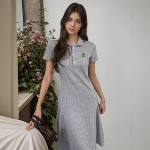 Détail d'une robe polo grise en maille côtelée avec logo et boutons blancs au col