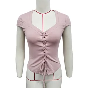 Detail of cross-lace drawstring design on pink slim-fit knit crop top for women