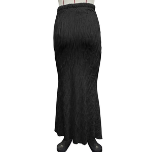 Close-up of the high-elastic pleated fabric and elegant fishtail hem on the black skirt