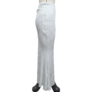 Detail of white pleated maxi skirt showing vertical texture and elastic waistband