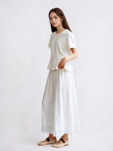 Elegant white two-piece set featuring short sleeve peplum top and long flowy skirt