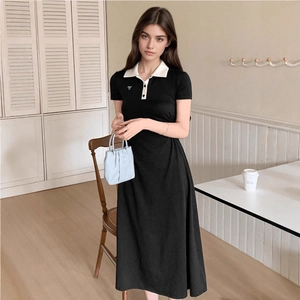 Detail of silver bow accent and white polo collar on a black slim-fit A-line dress