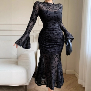 Detail of elegant black mesh dress featuring velvet floral flocking and flared bell sleeves