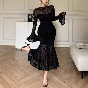 Detail of elegant black floral lace fabric with flared sleeves on a fishtail midi dress