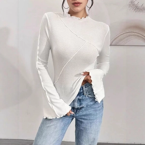 Slim fit white ribbed top with chic lettuce trim and decorative exposed seam stitching