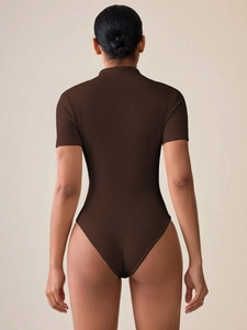 Detail of dark brown ribbed short-sleeve bodysuit featuring a high neck and sleek fit
