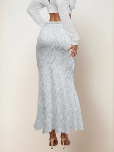 Macro detail of high-waist long skirt featuring unique wavy textured fabric and slim fit