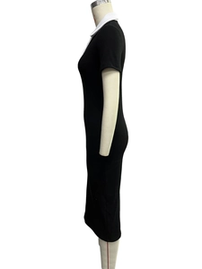 Dettaglio dell'abito in maglia nera aderente con colletto polo bianco a contrasto e maniche