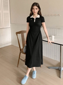 Short sleeve black polo dress with white collar and bow embroidery in a casual cafe setting