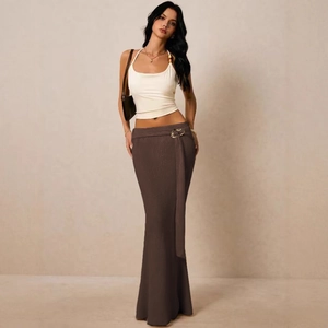Detail van bruine gebreide maxi-rok met metalen ring en gedrapeerd detail op de zij