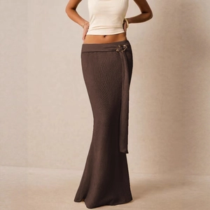 Detail van de donkerbruine gebreide maxi-rok met metalen ring en geribbelde textuur