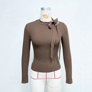 Close-up of ribbed brown long sleeve top featuring side bow-tie neckline detail