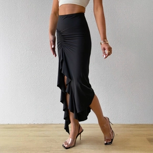 Detail of high waist black skirt with asymmetric ruffle hem and side slit design