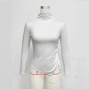 Detail of white mock neck top featuring side drawstring and asymmetrical hem design
