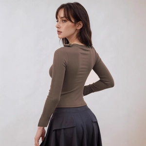 Detail of slim-fit brown ribbed knit top paired with a grey pleated skirt for women