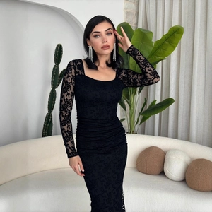 Dettaglio dell'abito elegante in pizzo nero con trama floreale e dettagli arricciati