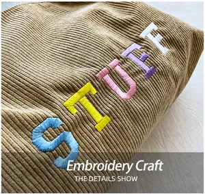 Detailed view of colorful STUFF embroidery on premium corduroy tote bag fabric