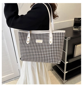 Dettaglio della borsa tote in lana pied de poule bianco e nero con manici in pelle bianca e borchie