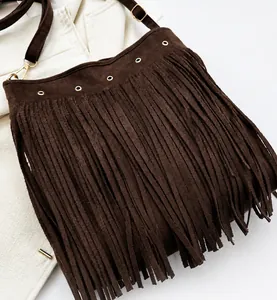 Detail of dark brown fringe shoulder bag with metal eyelets and adjustable strap