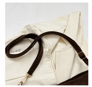 Detail of dark brown suede shoulder strap with light gold metal lobster clasp and buckle