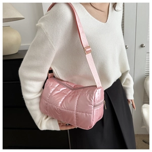 Détail du sac bandoulière rose matelassé avec sangle réglable et finitions métalliques dorées