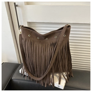 Close-up of dark brown suede shoulder bag with long fringes and golden eyelet details