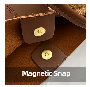 Close-up of golden magnetic snap and fine stitching on a brown leather tote bag