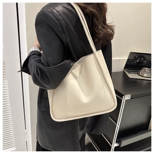 Minimalist cream white leather tote bag shown in a professional office setting