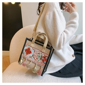 Close-up of ethnic floral embroidery and colorful tassels on the linen shoulder bag