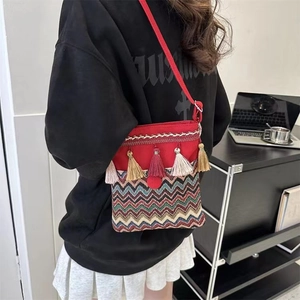 Ethnic style crossbody bag in red featuring colorful tassels and striped wave patterns